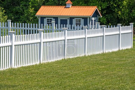 white vinyl fence fencing of private property grass plastic nature clean modern green garden