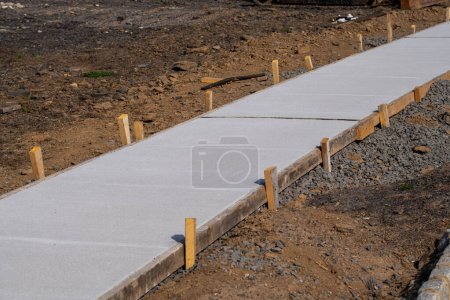 Téléchargez les photos : Nouvellement coulé trottoir en béton au chantier de construction résidentielle constructeur ciment foor ciment - en image libre de droit