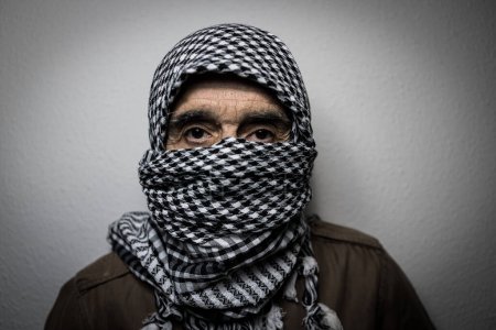 Téléchargez les photos : Portrait d'un militaire portant un foulard ou un shemagh palestinien, couvrant son visage, sur fond blanc. Concept de milicien, terrorisme, guerre, Palestine, Israël, terreur, peur, insécurité, conflit. - en image libre de droit