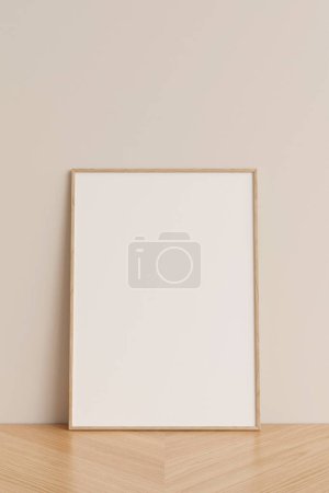 Téléchargez les photos : Vue de face nette et minimaliste photo verticale en bois ou maquette de cadre d'affiche appuyée contre le mur sur le sol en bois. Rendu 3d. - en image libre de droit