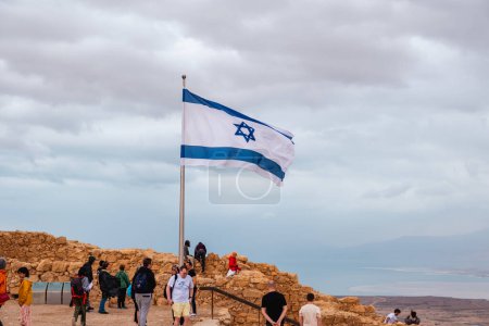 Téléchargez les photos : Désert de Judaean, District du Sud, Israël - 10 avril 2023. Touristes et drapeau israélien au parc national Masada. - en image libre de droit