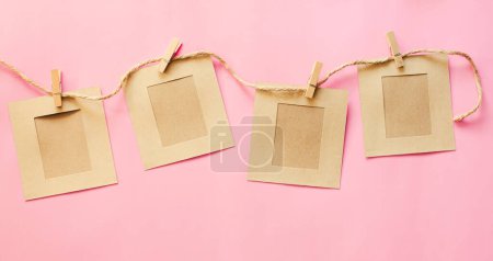 Foto de Papel marrón encordado con cuerda, dejando espacio para insertar letras sobre un fondo rosa. - Imagen libre de derechos