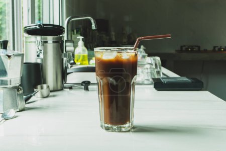 Photo for Iced black coffee on the glass on a marble bar with equipment to brew beverages make coffee at home - Royalty Free Image