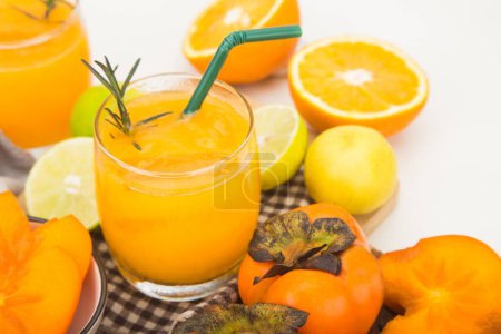 Foto de Jugo de caqui en un vaso y hay rodajas de naranja. concepto de bebida saludable - Imagen libre de derechos