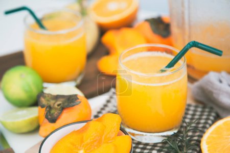 Photo for Persimmon juice in a glass And there are orange slices and a blender all around. - Royalty Free Image