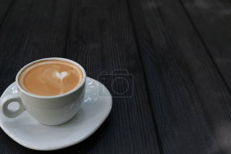 Foto de Taza de café caliente de arte latte, café en la mesa de madera por la mañana. Copia espacio para tu texto - Imagen libre de derechos