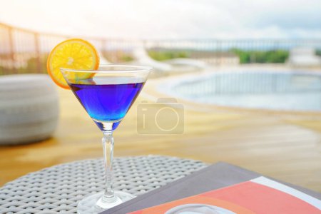 Téléchargez les photos : Une boisson rafraîchissante à base de soda aux myrtilles avec un peu d'orange sur le verre. boisson de vacances Détendez-vous au bord de la piscine sur le toit de l'un des hôtels en Thaïlande. - en image libre de droit