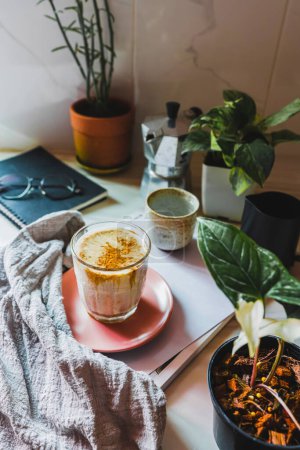 Foto de Espresso Coffee into Milk on top homemade coffee drink.decor plants on pot and glasses Vertical photo - Imagen libre de derechos