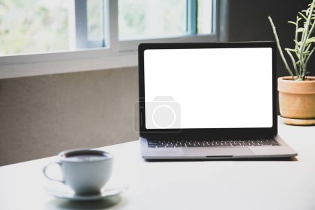 Foto de Dispositivos portátiles Mockup aislados sobre fondo blanco. portátil de ordenador personal pantalla blanca. y taza de café aroma, planta de interior, papel de anotador como un escritorio. oficina en casa - Imagen libre de derechos