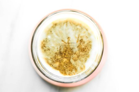 Photo for Top view of hot coffee with milk foam on a pink saucer placed on marble. close up - Royalty Free Image