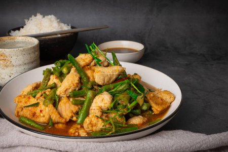 Tasty Stir-fried pork and red hot curry paste with asparagus bean or long bean and  Ingredients are oyster sauce, fish sauce, sugar, kaffir lime leaves in the dish Eat with cooked rice. Thai cuisine