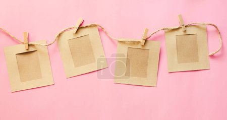 Photo for Brown paper strung with string, leaving space for inserting letters on a pink background. - Royalty Free Image
