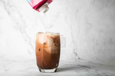 Photo for Poured almond milk Iced cocoa in clear glass on marble, copy space for your text - Royalty Free Image