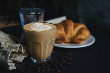 Photo for Hot coffee cup or latte art coffee Roasted coffee beans and croissants and Moka pot on black background, photographed at the studio. - Royalty Free Image