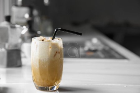 Photo for Glass of iced coffee with milk, Asian caffeinated beverages on a marble bar, and Moka Pot coffee pot in the kitchen home - Royalty Free Image