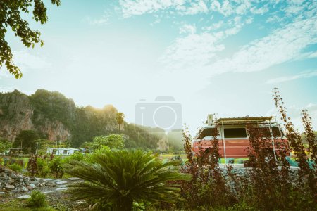 Photo for Classic pink sleeping car is parked on street with beautiful surrounding mountains in the evening light sunset Accommodation, attractions in Thailand. - Royalty Free Image