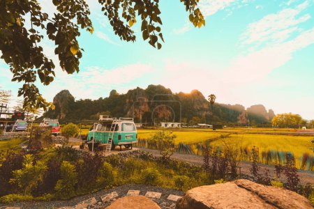 Photo for Classic green sleeping car is parked on street at Noen Maprang District Phitsanulok Province with beautiful surrounding mountains in the evening light sunset Accommodation, attractions in Thailand. - Royalty Free Image