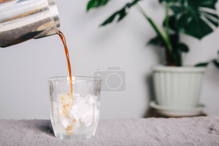 Photo for Barista Poured coffee of ice americano coffee into a transparent glass on table , homemade coffee - Royalty Free Image