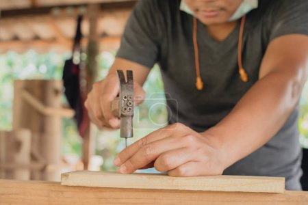 Foto de Enfoque suave artesano de madera usando un martillo clavos martilleo madera hacer que el producto de trabajo en carpintería taller muebles proyecto - Imagen libre de derechos
