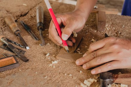 Foto de Artesano utilizando la marca de lápiz hacer en el producto de madera que trabaja en el proyecto de muebles de carpintería taller - Imagen libre de derechos