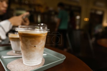 Foto de Café con leche helada en una taza de plástico colocada en una mesa en una cafetería. copiar espacio para su texto - Imagen libre de derechos