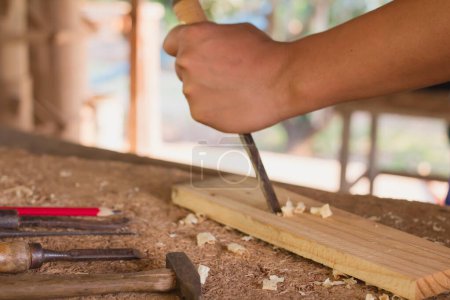 Foto de Artesano de madera utilizando las herramientas talladas hacen en el producto de madera que trabaja en el proyecto de muebles de taller de carpintería - Imagen libre de derechos