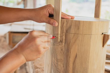 Téléchargez les photos : Artisan du bois à l'aide de la marque de crayon sur le produit de la boîte en bois travaillant au projet de meubles d'atelier de menuiserie - en image libre de droit
