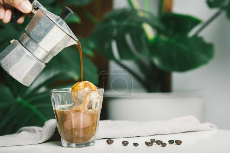 homemade Affogato, Italian Moka coffee pot, affogato is dessert with coffee as base ingredient typically scooping a scoop of gelato or vanilla ice cream into a cup. Then pour one shot of hot espresso.