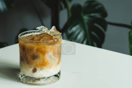 Photo for Iced latte coffee on the transparent glass on white a table background, homemade coffee, summer drink concept - Royalty Free Image