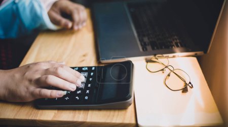 Hand Geschäftsmann mit Taschenrechner berechnen Einkommen auf Schreibtischarbeit von zu Hause aus
