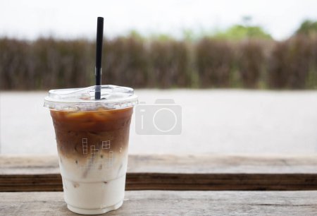 Photo for Iced of latte coffee cup on wooden backdrop grass nature background. Copy space for text - Royalty Free Image