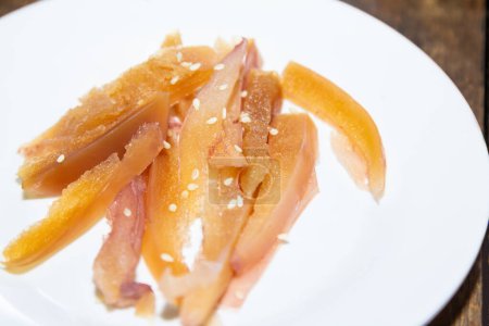 Foto de Hervir calamar crujiente y semillas de sésamo blanco en la parte superior con ingredientes y materias primas, comer shabu, Sukiyaki en un plato blanco. - Imagen libre de derechos
