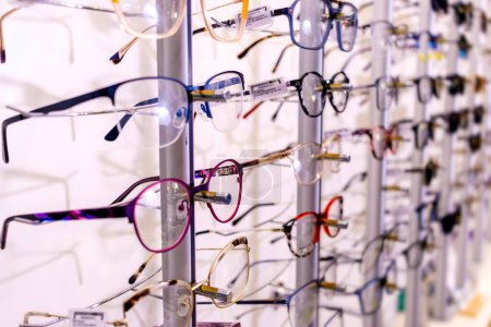 Photo for In optician shop. Different glasses for sale in wall rack. - Royalty Free Image