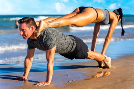 Photo for Sports stretching.Couple practicing sport on the beach. - Royalty Free Image