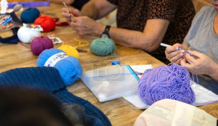 Photo for Crochet club. Ladies crocheting with colored wool. - Royalty Free Image