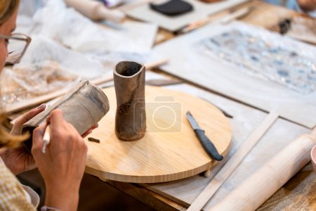 Atelier de céramique. Femme travaillant avec des outils en céramique