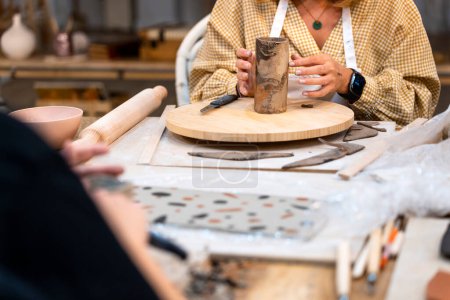 Atelier de céramique. Femme d'âge moyen tournant l'argile.