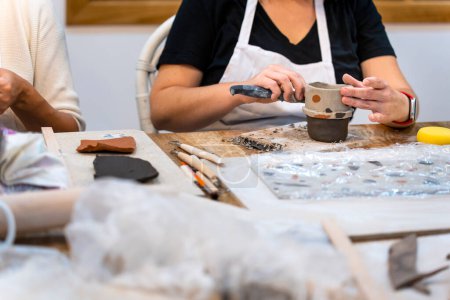 Photo for Ceramic Workshop. Middle aged woman working on her new ceramic creation - Royalty Free Image
