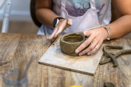 Keramische Werkstatt. Frau mittleren Alters arbeitet an ihrer neuen Keramik-Kreation