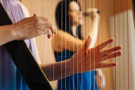Photo for Hungarian harpist playing an electronic harp with a Latin singer - Royalty Free Image