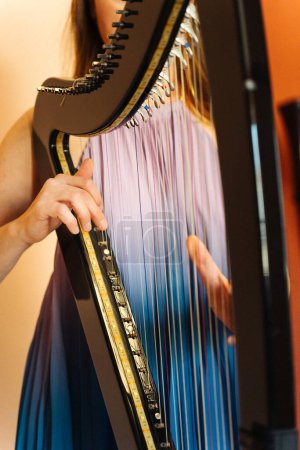 Photo for Hungarian harpist playing an electronic harp - Royalty Free Image