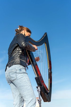 Photo for Harpist with electronic harp studying on the roof - Royalty Free Image