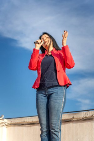 Photo for Latin singer during a rehearsal on the roof of the building - Royalty Free Image