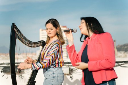 Photo for Harp and voice duo performing on the roof of the building - Royalty Free Image