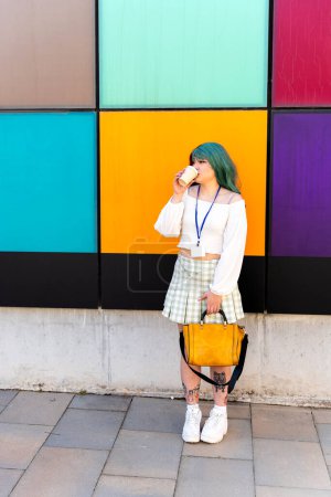 Modernes Mädchen mit rotem und grünem Haar bei einem Kaffee im Stehen