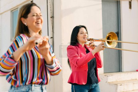 tromboniste et flûtiste féminine riant d'une répétition