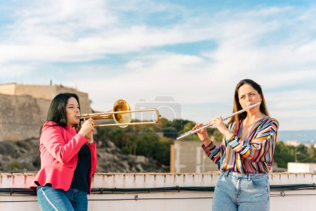 Female trombonist and flutist at a rehearsal