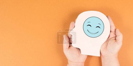Foto de Sostener una cabeza con una cara sonriente feliz, concepto de salud mental, mentalidad positiva, apoyo y símbolo de evaluación - Imagen libre de derechos