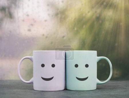 Happy, similing face, mug couple on a window sill cuddle, cup of coffee on a rainy day, support, relationship and friendship concept