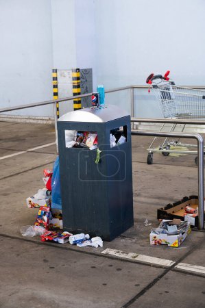 Photo for Overflowing dumpster, trash can with plastic bags and cardboard, filthy shopping center, Alleencenter in Trier, Germany - Royalty Free Image